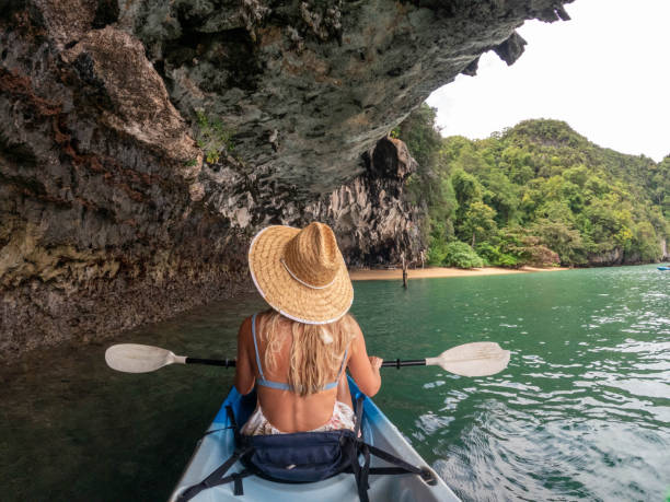 istock Young woman kayaking in tropical setting, rear view 1919812789