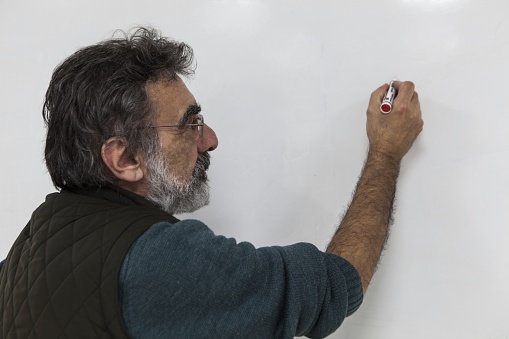 The professor writing on the white board.