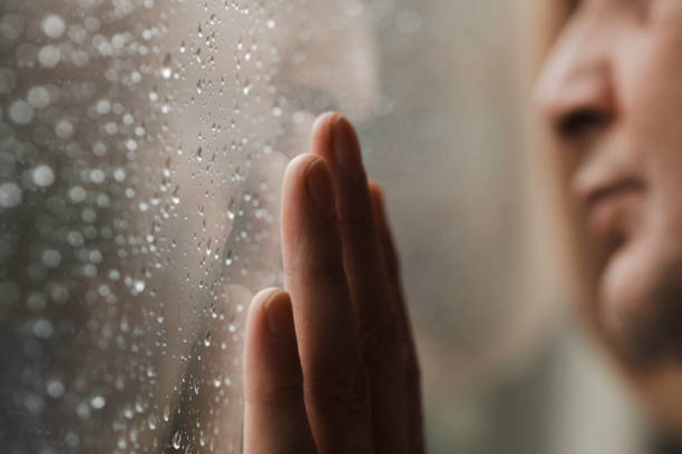 istock Anxious Man Looking Outside in Rainy Weather 1919843770