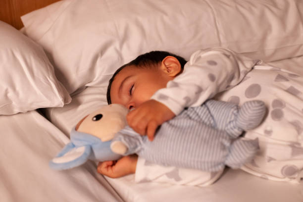 istock Baby sleeping with teddy bear in bed 1919860063