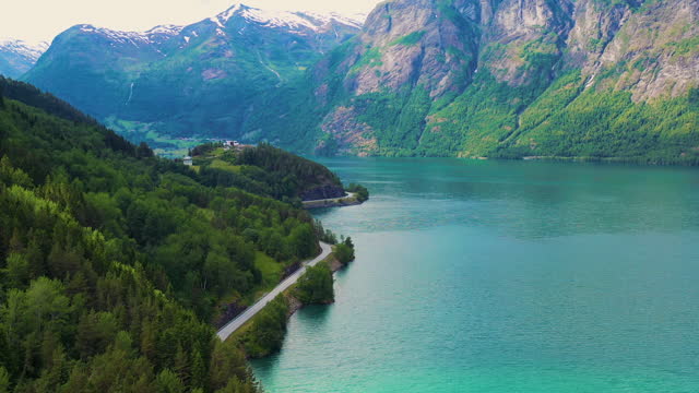 Aerial View of Car Driving Scenic Summer Landscape by Crystal Blue Fjord with Idyllic Mountain View in Norway