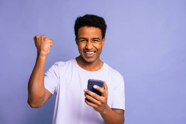 istock Excited Young Man Celebrating Victory on Phone 1919862783