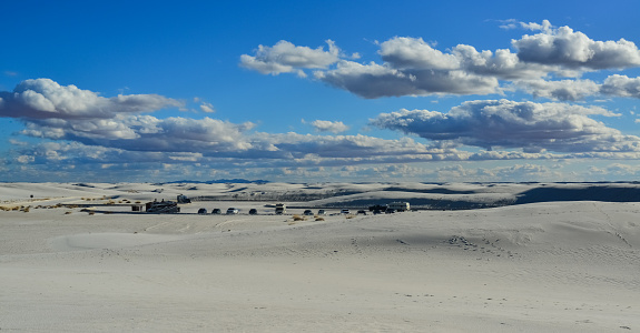 USA, NEW MEXICO - NOVEMBER 23, 2019:  Desert landscape of gypsum dunes, tourist cars among sand dunes in White Sands National Monument in New Mexico, USA