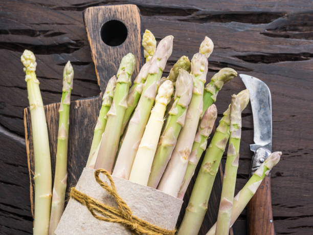 istock White fresh asparagus sprouts on wooden table. Royal vegetable. 1919899454