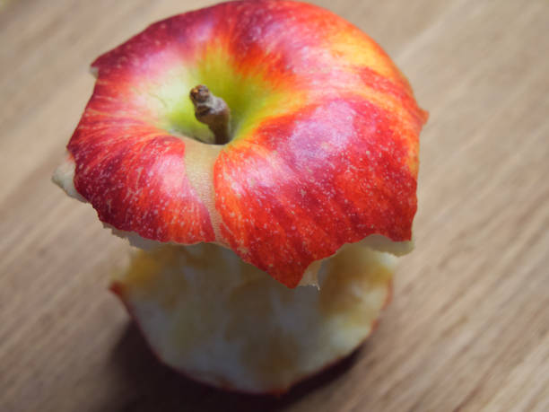 istock Red apple core on a wooden background. A bitten apple close-up. 1919909599