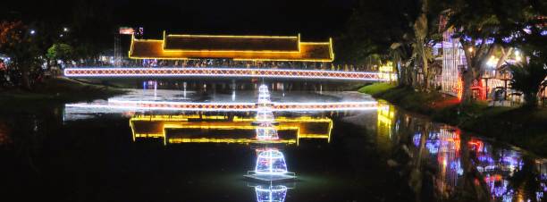 istock A photograph capturing a brightly lit bridge spanning a small river in Siem Reap, Cambodia, with the light colors reflecting on the water surface. 1919914507