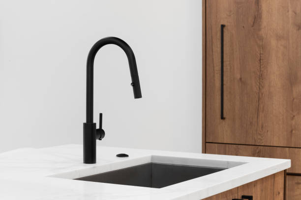 istock A black kitchen faucet on white marble and wood cabinets. 1919929865