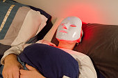 Headshot of woman with light therapy facial mask