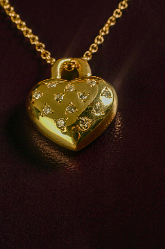 Heart necklace in gold - leather background