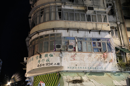 Old, messy condominium in Sham Shui Po district by night, Kowloon Peninsula.