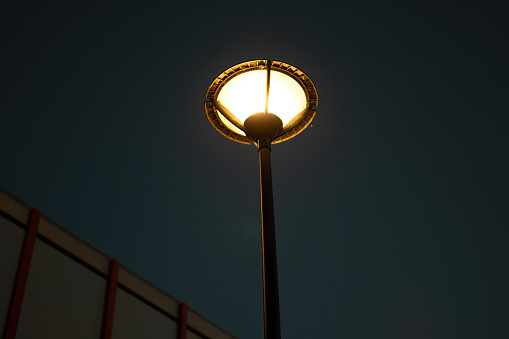 LED lantern for street lighting. Modern street lamp on a metal pole against the blue sky with white clouds. Modern LED lamp street lighting.
