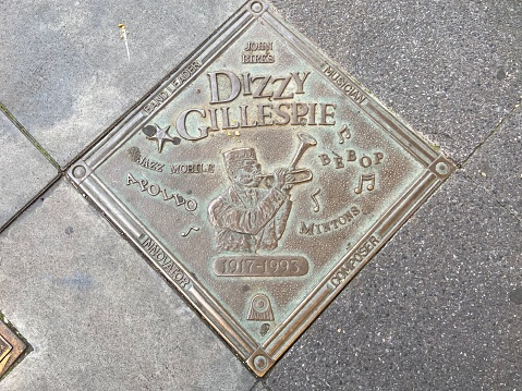 New York, NY USA - September 16, 2023 : Close-up of bronze plaque honoring jazz musician Dizzy Gillespie with an image of him playing the trumpet on the Harlem Walk of Fame on 135th Street in Harlem, New York City, USA