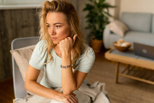 istock Blonde woman is sitting on a chair covered with a blanket 1920003940
