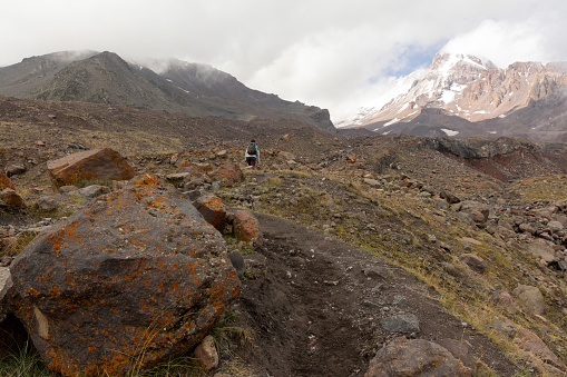 Tourist woman hiking in Georgia on Kazbek moutain in Caucasus moutains peak in summer