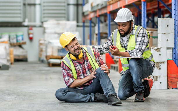 istock Professional male worker help his colleague after getting accident, injured leg while working in factory or warehouse. Safety, Industry, Healthcare, Insurance Concept. 1920014589