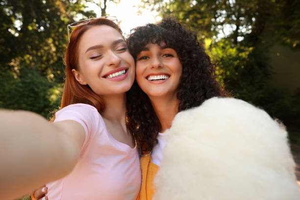 istock Happy friends with cotton candy taking selfie outdoors 1920041866