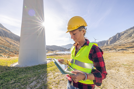 Female engineer inspecting wind turbines, Electrician or technician for a sustainable future