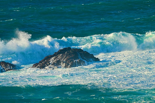 Huge ocean waves crushing on rocks in Garrapata State Beach in California