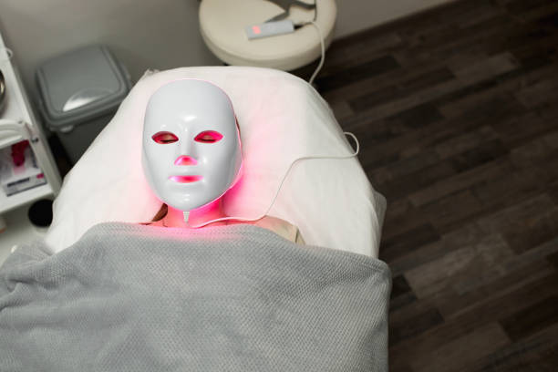 istock Beautiful young woman getting a led light therapy mask treatment for her face 1920065589