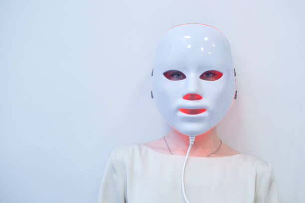 istock Beautiful young woman getting a led light therapy mask treatment for her face 1920068255