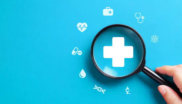 istock Health insurance concept with magnifying glass on blue background 1920086865