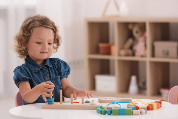 istock Motor skills development. Little girl playing with stacking and counting game at table indoors 1920093194
