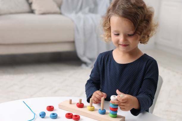 istock Motor skills development. Little girl playing with stacking and counting game at table indoors 1920096444