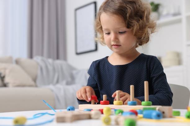 istock Motor skills development. Little girl playing with stacking and counting game at table indoors 1920096445