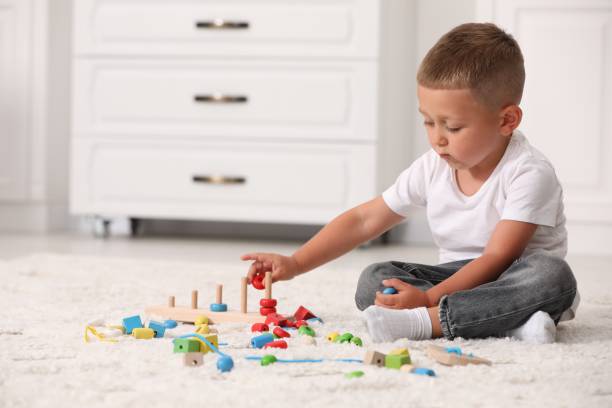 istock Motor skills development. Little boy playing with stacking and counting game on floor indoors 1920096995