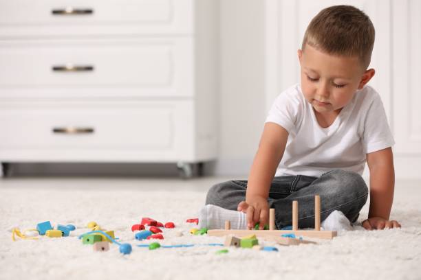 istock Motor skills development. Little boy playing with stacking and counting game on floor indoors 1920097003