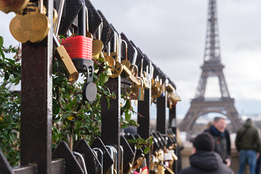 Paris, France - January 1, 2024: Couples show their love by attaching padlocks to the gates of the Trocadero garden.