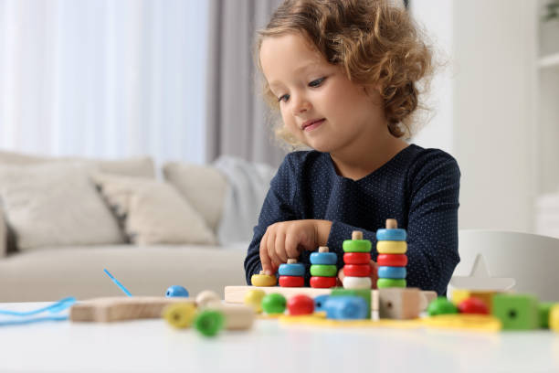 istock Motor skills development. Little girl playing with stacking and counting game at table indoors 1920104348