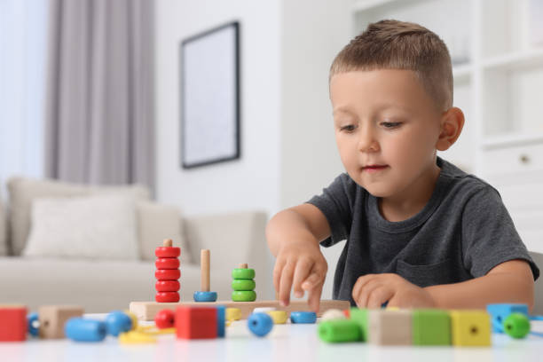 istock Motor skills development. Little boy playing with stacking and counting game at table indoors 1920104870
