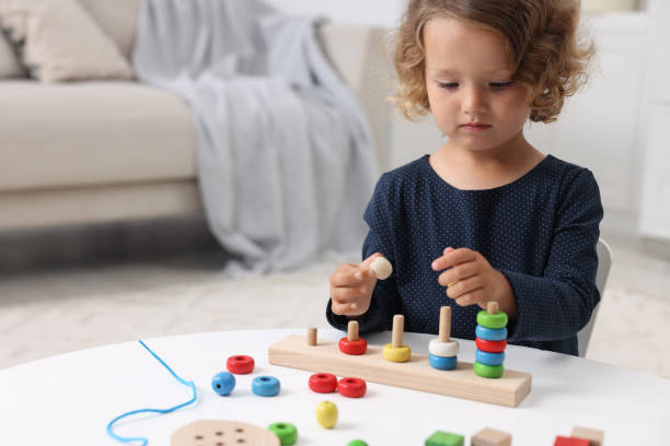 istock Motor skills development. Little girl playing with stacking and counting game at table indoors 1920106441