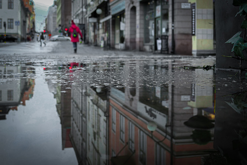 Brussels, Belgium - January 31, 2013: A McDonald's sign and surrounding buildings are seen in a large puddle of rainwater on a sidewalk in downtown Brussels.