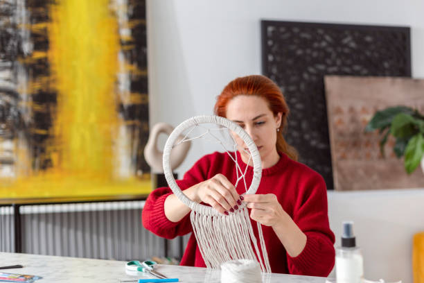 istock Woman weaves macrame in living room 1920148094