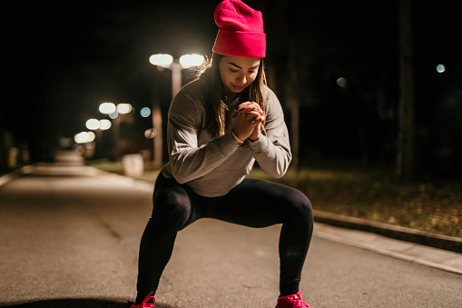 young woman exercising at night