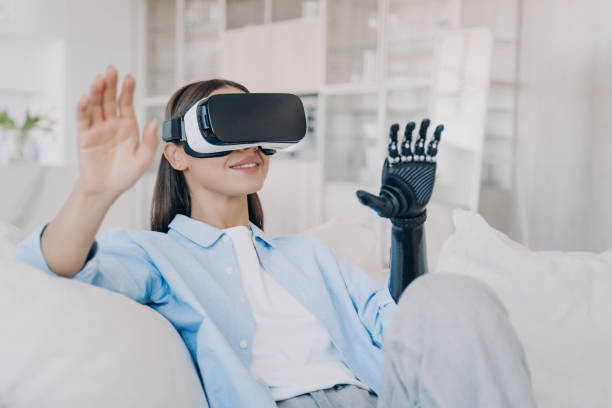istock Engaged young woman with bionic arm exploring virtual reality, seated comfortably in a bright living room 1920170649