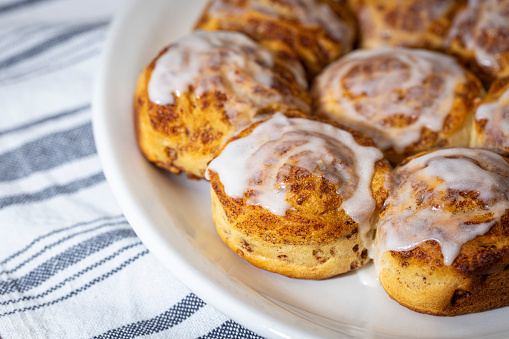 Plate of fresh-baked cinnamon rolls with icing