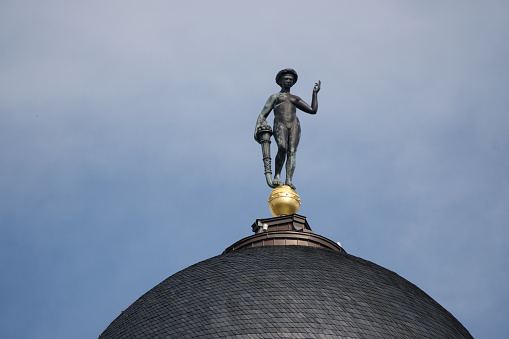 The image showcases a golden statue perched atop a historical dome in Berlin, embodying the city's rich cultural heritage and artistic expression.