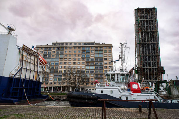 Tugboat, cargo ship and drawbridge in the port of Saint-Nazaire in Brittany, France