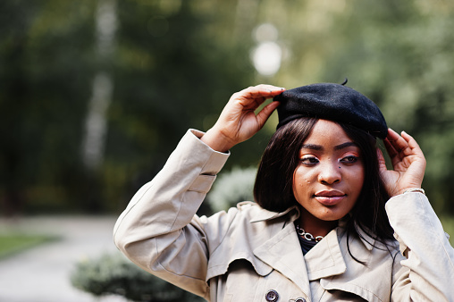 Close up portrait of fashionable african american woman wear beret and coat posing outdoor.