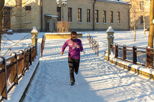 Grodno, Belarus - January 03, 2024: Young man participates in winter orienteering training in urban conditions. Outdoor orienteering check point activity