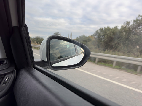 Driving on the motorway. Road reflection from the mirror. No people.