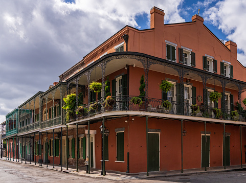 Hanging baskets on tradional New Orleans corner building in the French Quarter with wrought iron railings and balconies