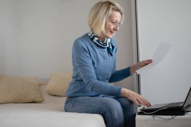 istock mature blond woman working on laptop planning finances 1920333772