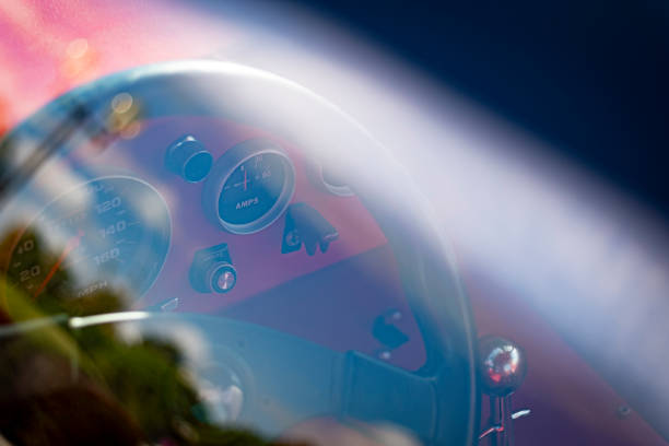 Many old clocks inside a red sports car cockpit
