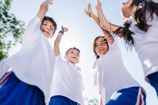 istock Child students stacking hands and celebrating outdoors 1920374901