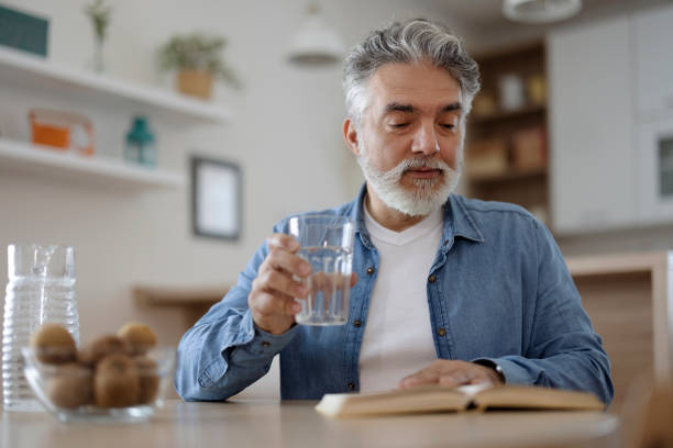istock Bearded Mature Man Reading Book at Home 1920384342