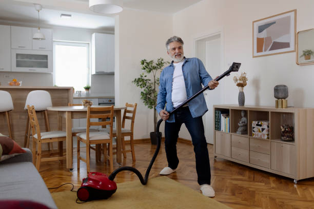 istock Bearded Mature Man Dancing Happily With a Vacuum Cleaner 1920392091
